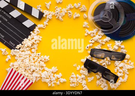 Clapperboard, 3D glasses and popcorn on yellow background Stock Photo
