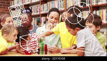 Supervising woman in green blouse guiding children mixing liquids with test tubes at library table Stock Photo