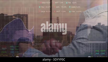 Shaking hands between two men in collared shirts in office with skyline and financial overlays Stock Photo