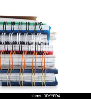 Stack of many different notebooks isolated on white background Stock Photo
