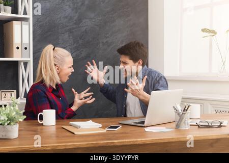 Couple of young colleagues arguing at office Stock Photo