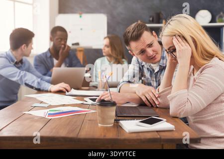 Man supporting woman reading bad news in email Stock Photo