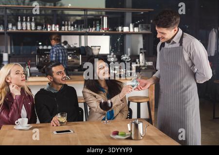 Smiling waiter taking payment from client Stock Photo