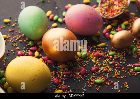 Colored eggs and scattered candies Stock Photo