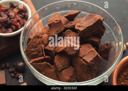 Crushed chocolate pieces in bowl on black background Stock Photo