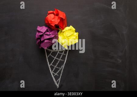 Drawn ice-cream cone and crumpled paper balls on black background Stock Photo