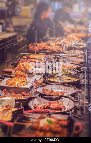 A wide selection of dishes in the Buffet restaurant – Meat, vegetables, pies and sauces cooked on professional heated baking trays are laid out on Stock Photo