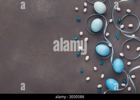 Easter background. Colored eggs and sweets on gray stone surface Stock Photo