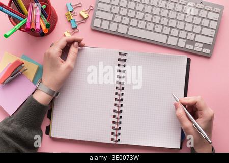 Woman's hands writing in spiral notepad Stock Photo