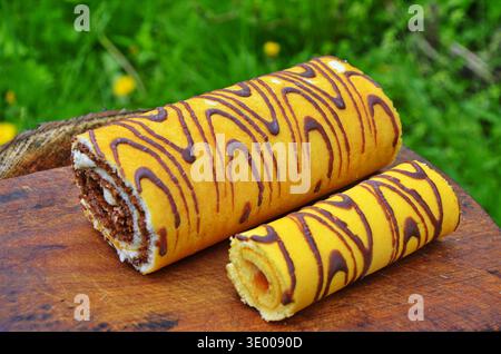 Attractive roll in chocolate and flowers. Stock Photo