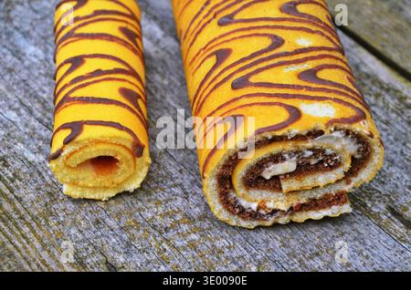 Attractive roll in chocolate and flowers. Stock Photo