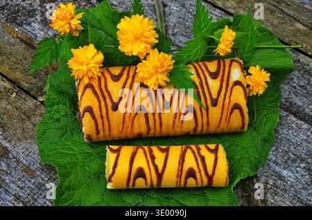 Attractive roll in chocolate and flowers. Stock Photo