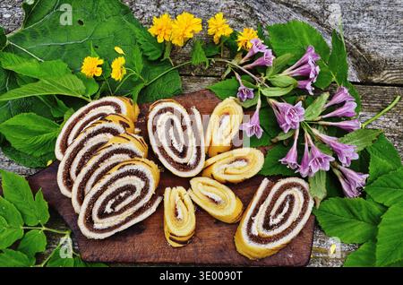 Attractive roll in chocolate and flowers. Stock Photo