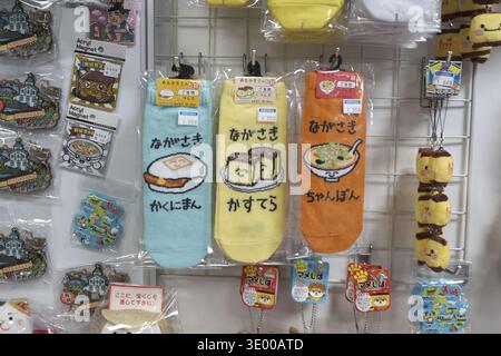 Colorful souvenir socks with cute food illustrations of Nagasaki specialties: Kakuniman, Castella, and Champon, displayed at a gift shop Stock Photo