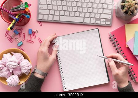Woman's hands writing in spiral notepad Stock Photo