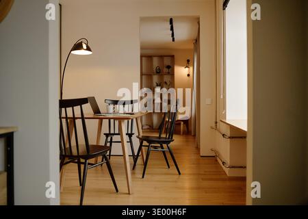 Modern Home Workspace Featuring Laptop on Wooden Table in Bright Interior Stock Photo