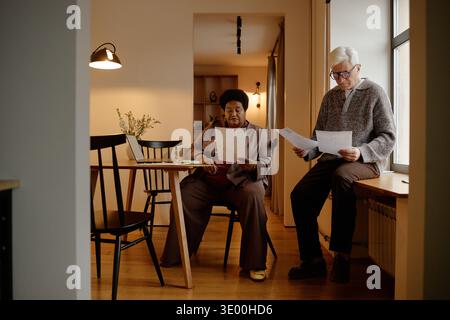 Biracial Senior Couple Reading Documents while Managing Utility Bills at Home Stock Photo