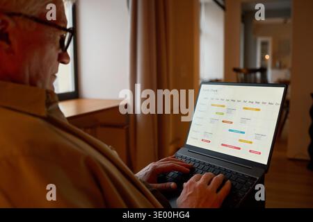 Senior Caucasian Man Using Laptop While Planning Schedule at Home Stock Photo