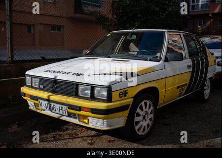Front three-quarter view of a vintage Renault 11 GTL with yellow and black Elf rally racing livery and decals parked on an urban street. Stock Photo