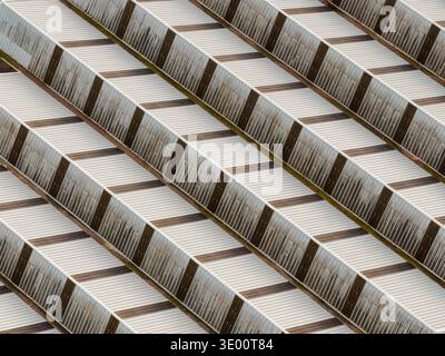 Aerial view of rhythmic patterns of light and shadow dance across the corrugated rooftops, creating a mesmerizing geometric tapestry, Settecamini, Laz Stock Photo