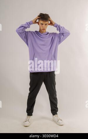 Handsome young guy in stylish clothes on white background in photo studio posing for camera Stock Photo