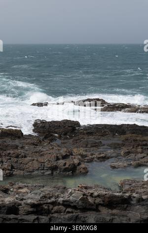 Atlantic waves flowing over volcanic rocks and natural pools along the rugged coast of Aguas Verdes in Fuerteventura Canary Islands. Stock Photo