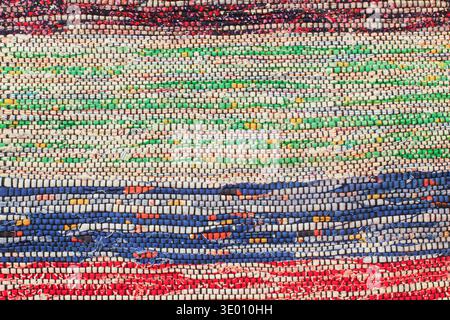 Bright multicolored hand-woven rag rug texture with blue, green and red stripes Stock Photo