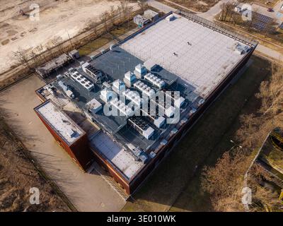 Aerial view of data center building with numerous air conditioning and ventilation systems on roof for server cooling, Warsaw, Masovian Voivodeship, P Stock Photo
