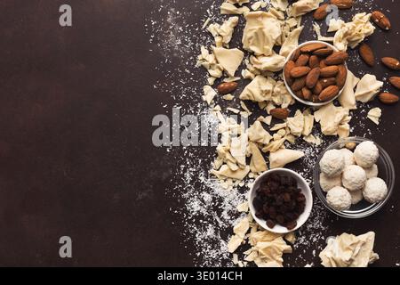 Crushed white chocolate pieces and truffles on dark background Stock Photo