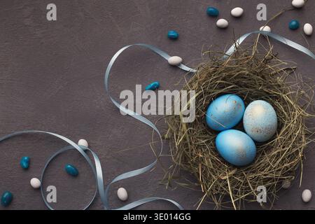 Easter background. Colored eggs in nest on gray stone surface Stock Photo
