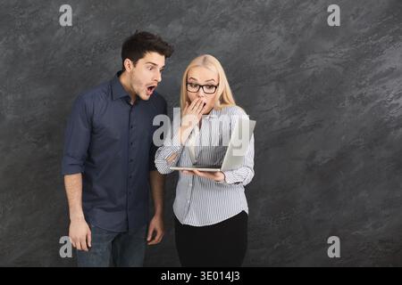 Shocked couple using laptop at studio Stock Photo