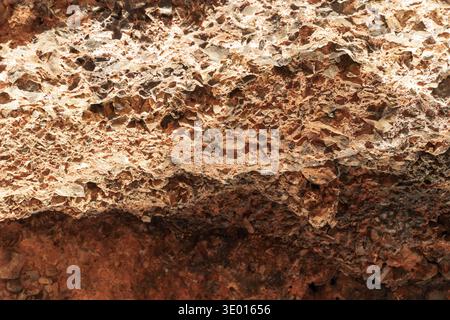 Natural rocky cliff texture with brown stones and rough geological surface pattern Stock Photo