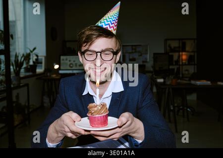 Portrait of Young Adult Caucasian Man Smiling While Celebrating Birthday Indoors Stock Photo