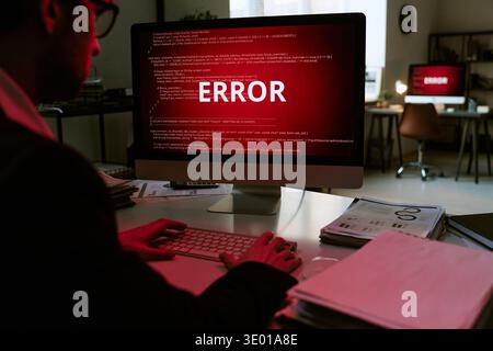 Young Adult Caucasian Man Working on Computer Displaying Error Message Stock Photo