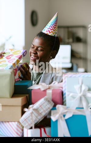Vertical of Black Woman Smiling While Receiving Birthday Presents at Celebration Stock Photo