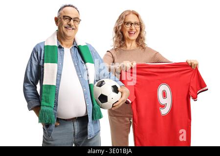 Mature man with a football and woman holding a red jersey top isolated on white background Stock Photo