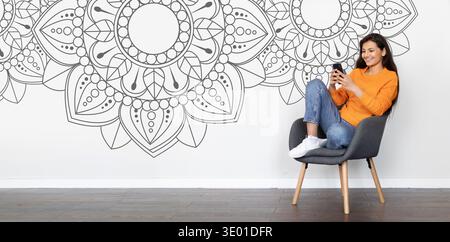 Collection of Black and White Patterns on Wall With Person Using Smartphone in Chair Stock Photo