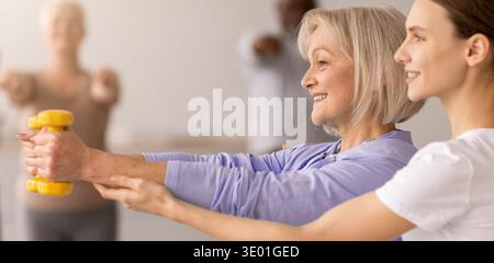 Seniors Engage in Exercise Class With Support From Instructor in a Bright Studio Space Stock Photo
