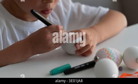 Child Decorating Easter Egg with Marker Close Up Stock Photo