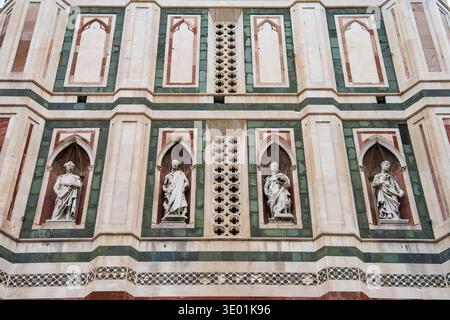 Close-up details of Florence Cathedral's exterior facade (Cattedrale di Santa Maria del Fiore), showcasing intricate marble and Gothic design. Florenc Stock Photo
