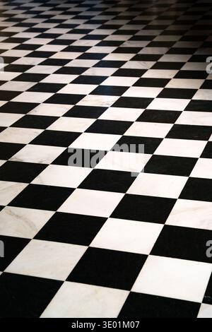 A classic black and white checkered marble floor, creating a deep, timeless pattern ideal as a background or texture. Stock Photo