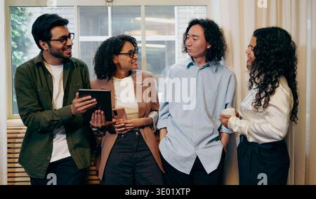 Work Colleagues Sharing Thoughts During Chat, Group Of Coworkers Discussing Ideas In Relaxed Setting Stock Photo