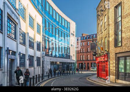 Modern glass office building and traditional red pub on Stephen Street Lower in Dublin city center. Stock Photo