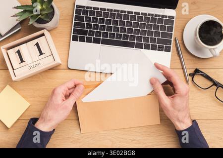 Man open envelope at workplace while working Stock Photo