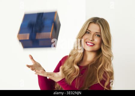 Happy woman with a gift falling in her hands for birthday, anniversary, wedding, Valentines day or Christmas, luxury holiday present or beauty box sub Stock Photo