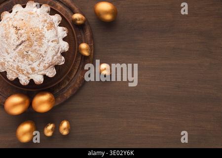 Easter cake and golden eggs on wooden table Stock Photo