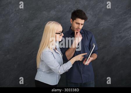 Serious business partners using digital tablet at studio Stock Photo