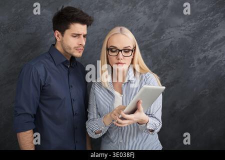 Serious business partners using digital tablet at studio Stock Photo