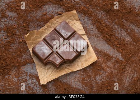 Crushed chocolate bar pieces and cocoa on gray background Stock Photo