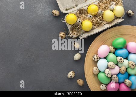 Colored Easter and quail eggs set on black table Stock Photo